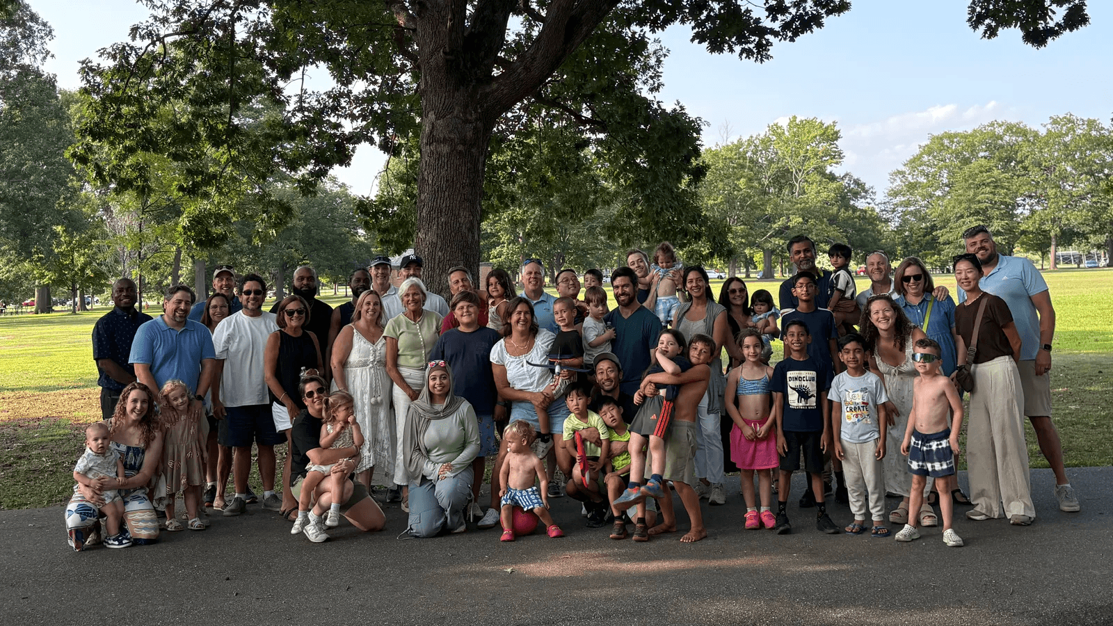 The Astarita Associates team and their families gathered under a large oak tree at Eisenhower Park
